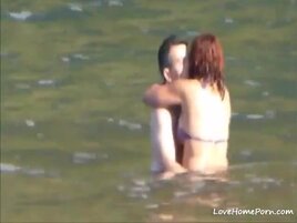 Horny couple having some fun in the water at the beach
