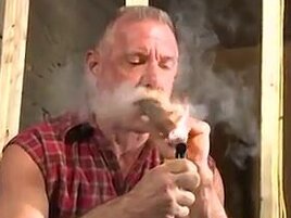 Scott Reynolds smokes a cigar while playing with his cock
