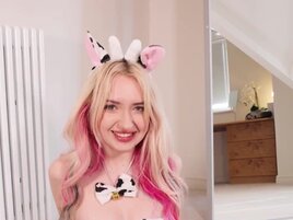 Kitty Marie wears a cow outfit while playing with a toy